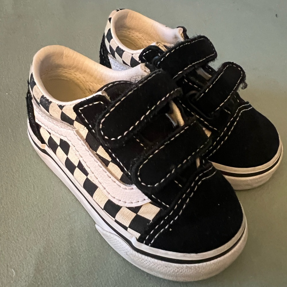 Toddler checkered black and white Vans with Velcro strap.